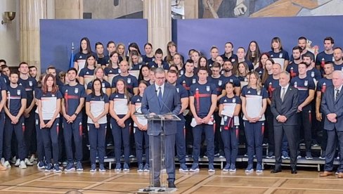 VUČIĆ SA OLIMPIJCIMA: Predsednik srpskom timu uručuje državnu zastavu koju će nositi na Igre